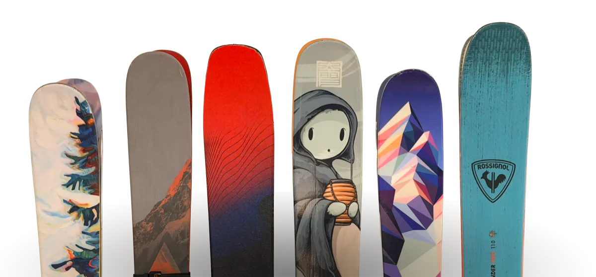 Six pairs of skis leaning against a wall